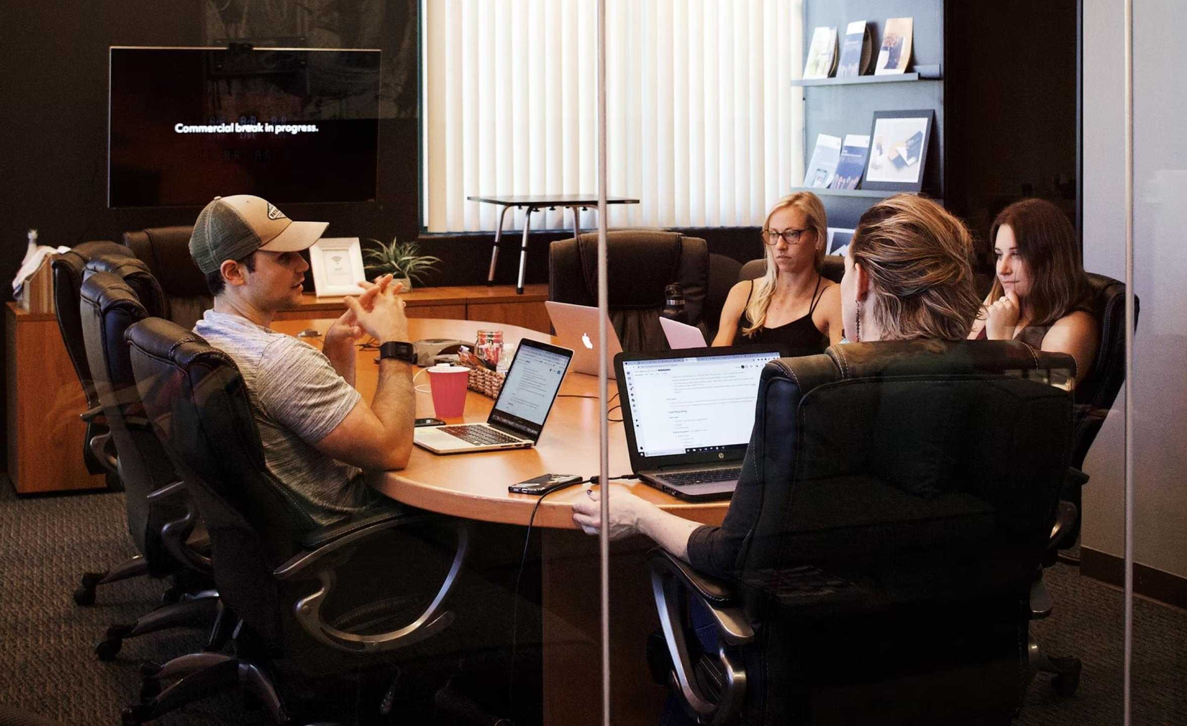 Deriv staff having a discussion with their laptops